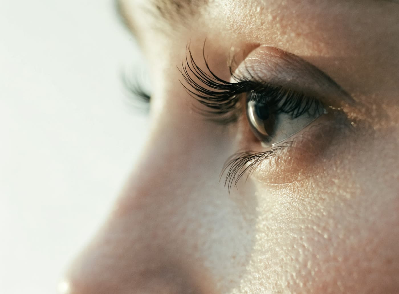 Nahaufnahme einer Augenpartie im Profil mit geschwungenen Wimpern